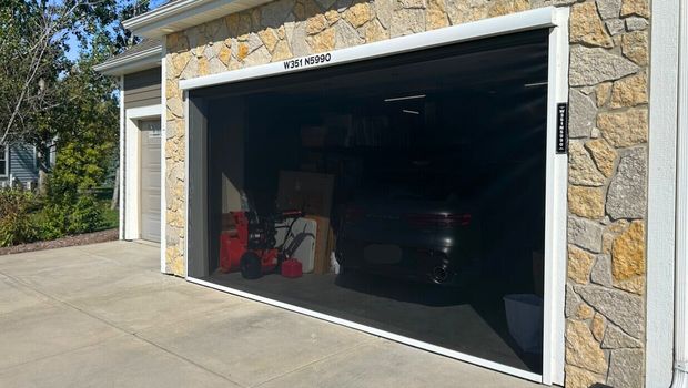 Apollo motorized garage screen with heavy gauge housing on a double stone-facade garage